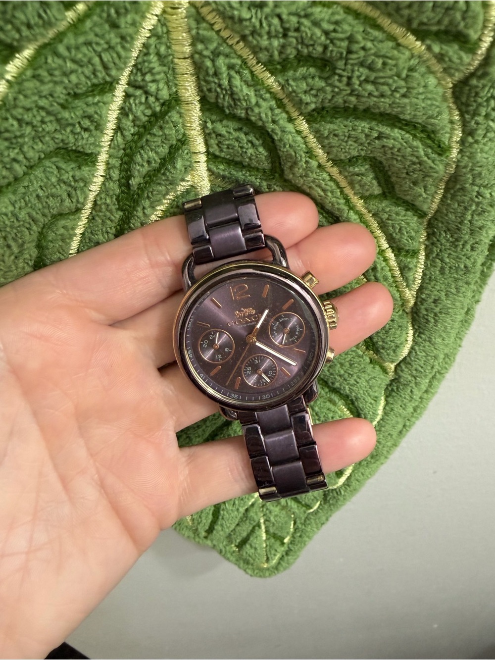 Woman’s purple and gold coach watch